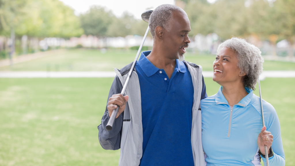 couple holding clubs on the golf course