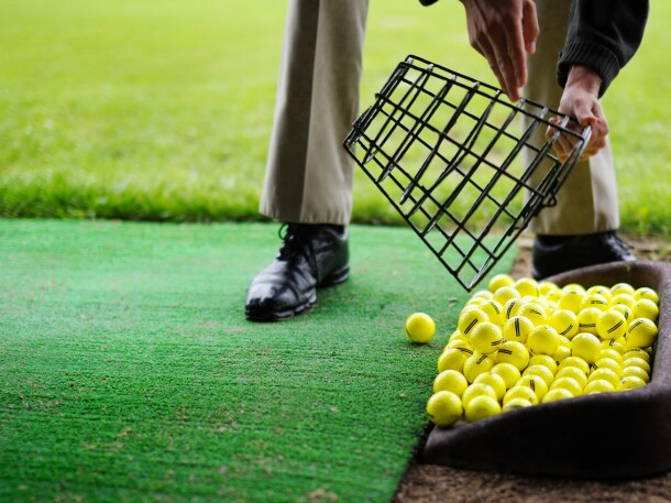 range balls pouring out of basket at golf practice facility