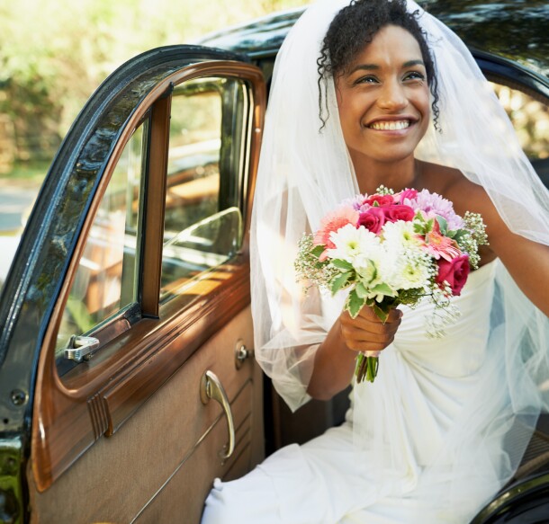 bride being helped out of the backseat of a car