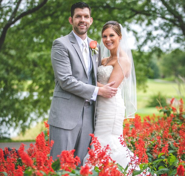 bride and groom under tree and by flowers at Orchard Valley Golf Course wedding