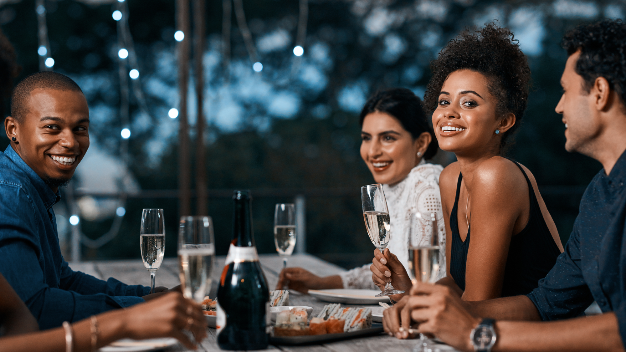 couples or group of friends celebrating with champagne at dinner