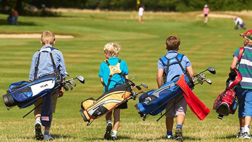 junior golfers walking golf course