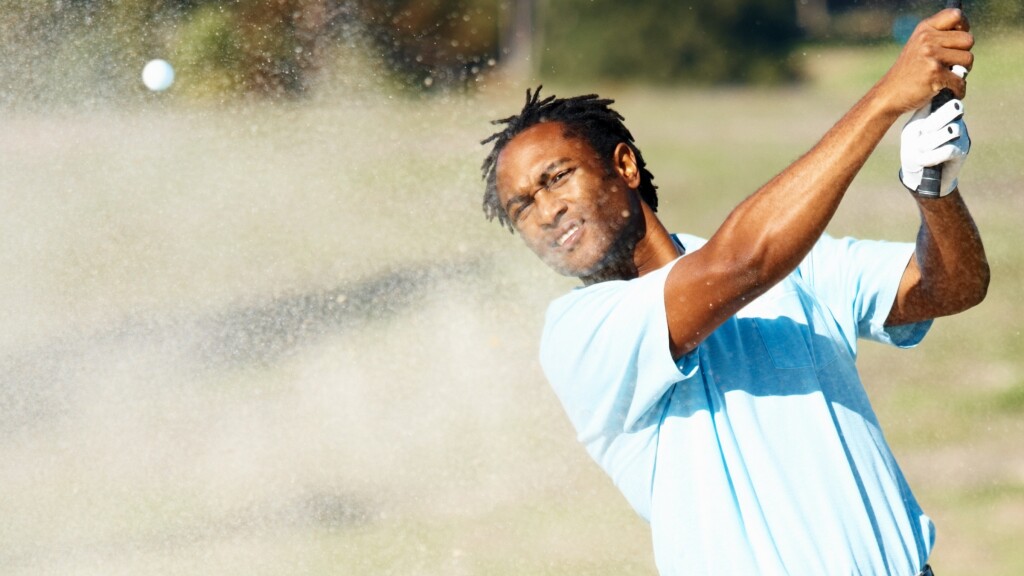 golfer hitting golf ball from bunker sand trap