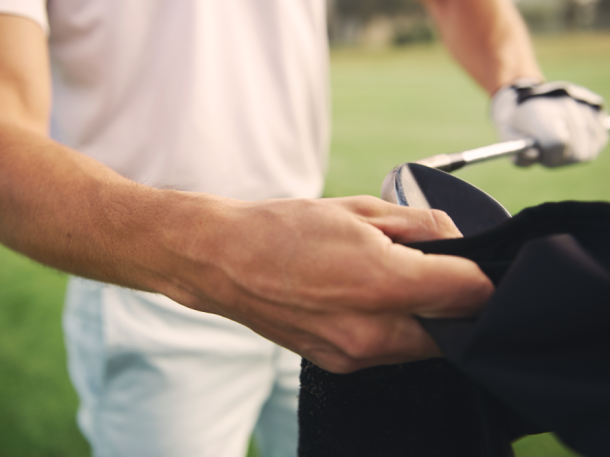 man cleaning golf club