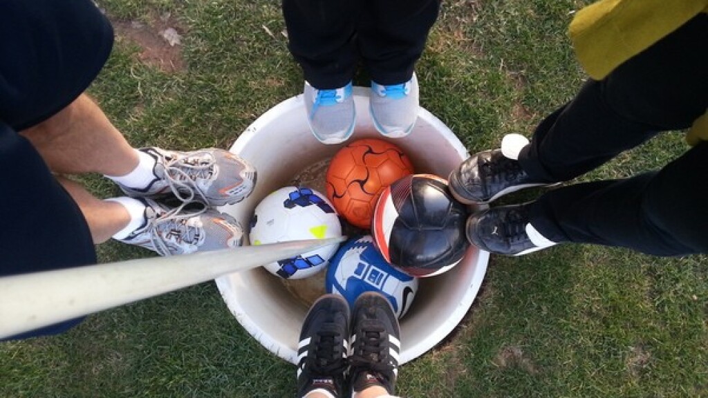 FootGolf - feet and soccer balls circled around hole