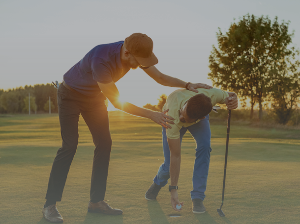 Golf instructor teaching student putting