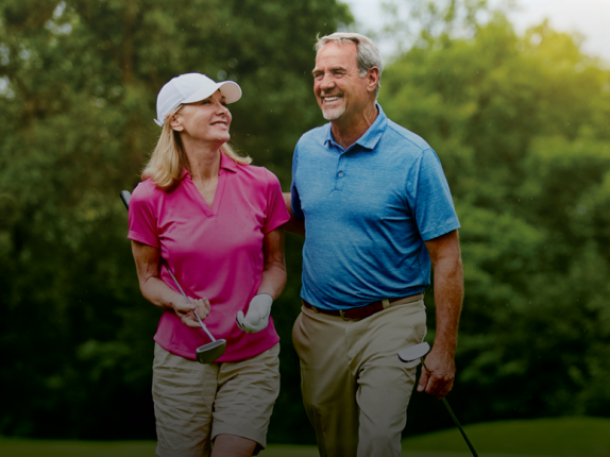 senior couple coed golfers on course