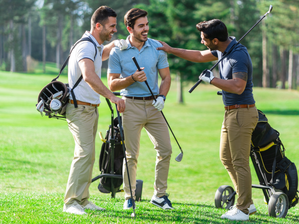 threesome of golfer guys holding clubs