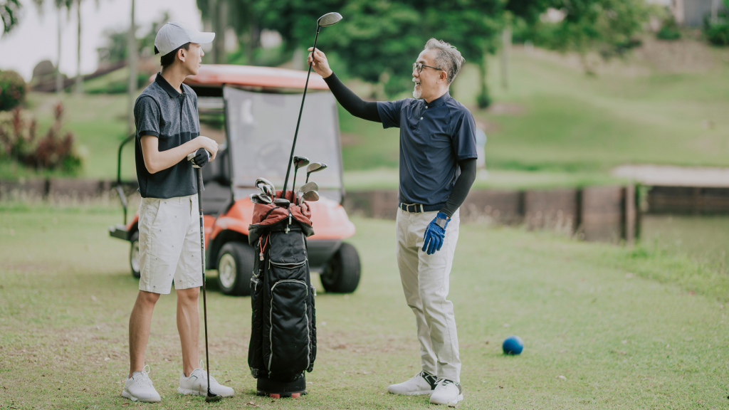 father son discussing golf game and choosing golf clubs at tee