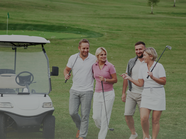 foursome of golfer couple holding clubs walking by golf cart