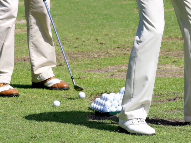 two golfers hitting range balls at golf practice facility