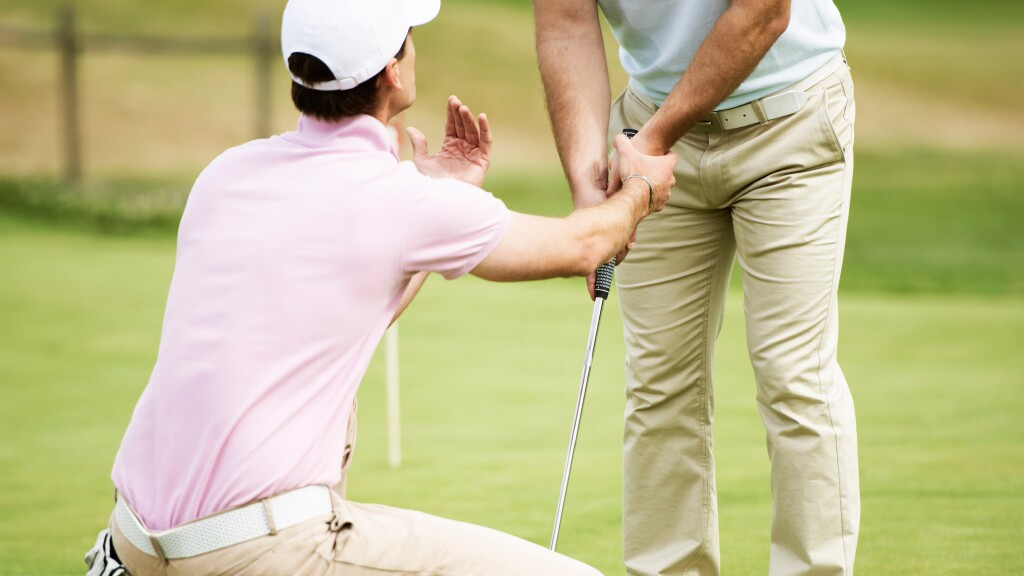 golf instructor teaching student grip