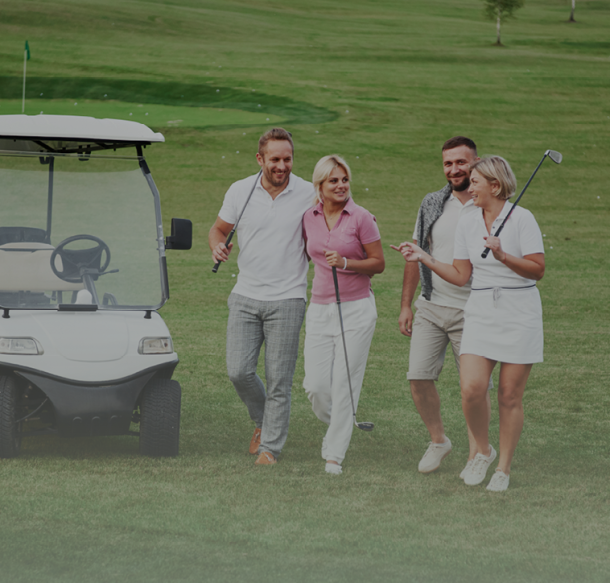 foursome of golfer couple holding clubs walking by golf cart